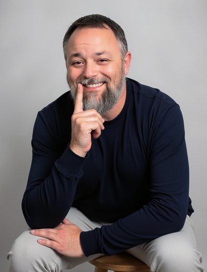 Portrait of Fred Cook seated, smiling with his hand on his chin